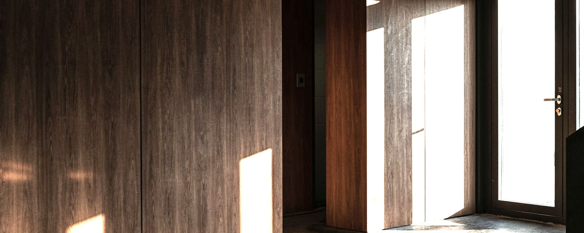The consulting room doors, late daylight across the floor.