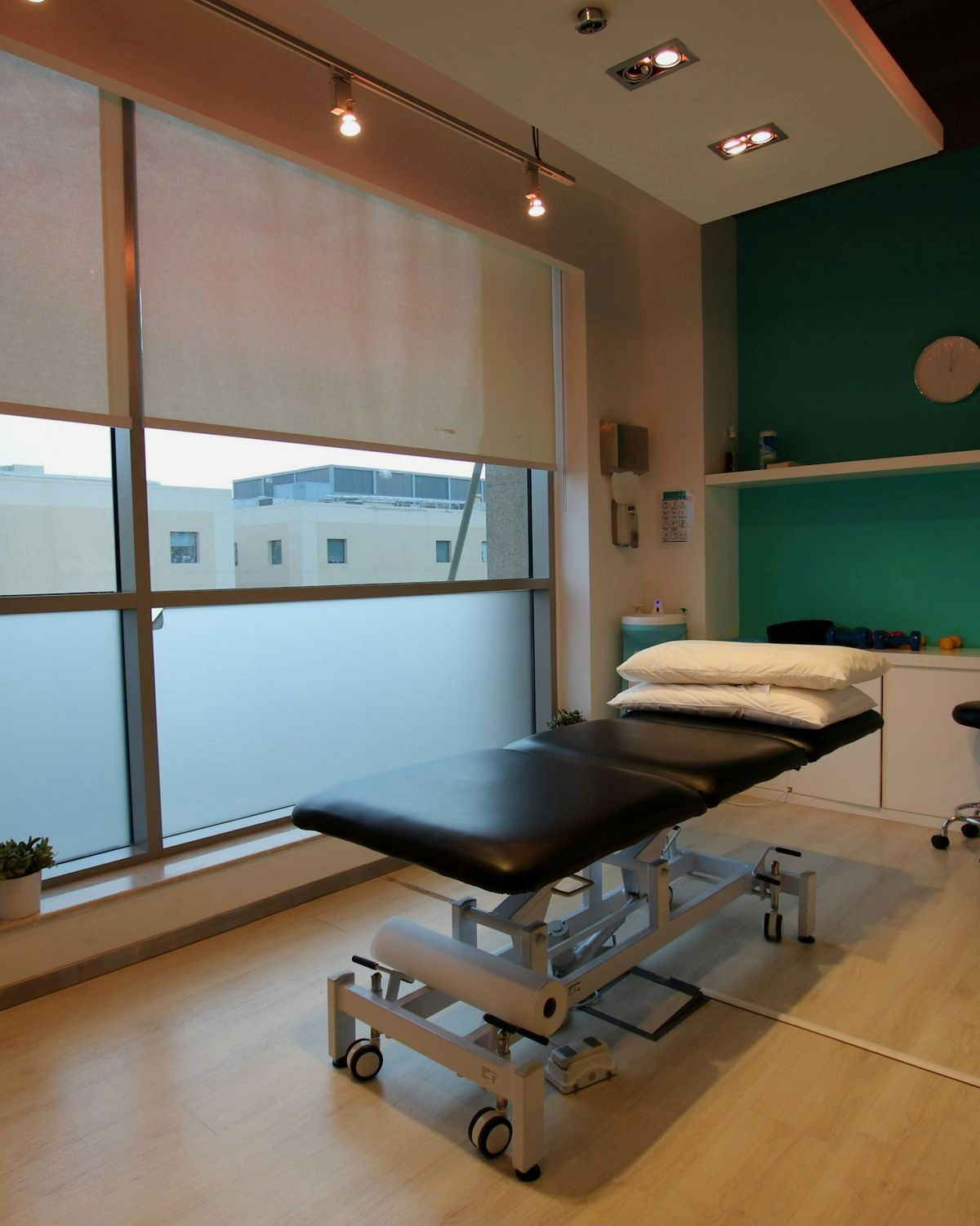 Treatment room one — the couch, the supply trolley and the window it is set beside.