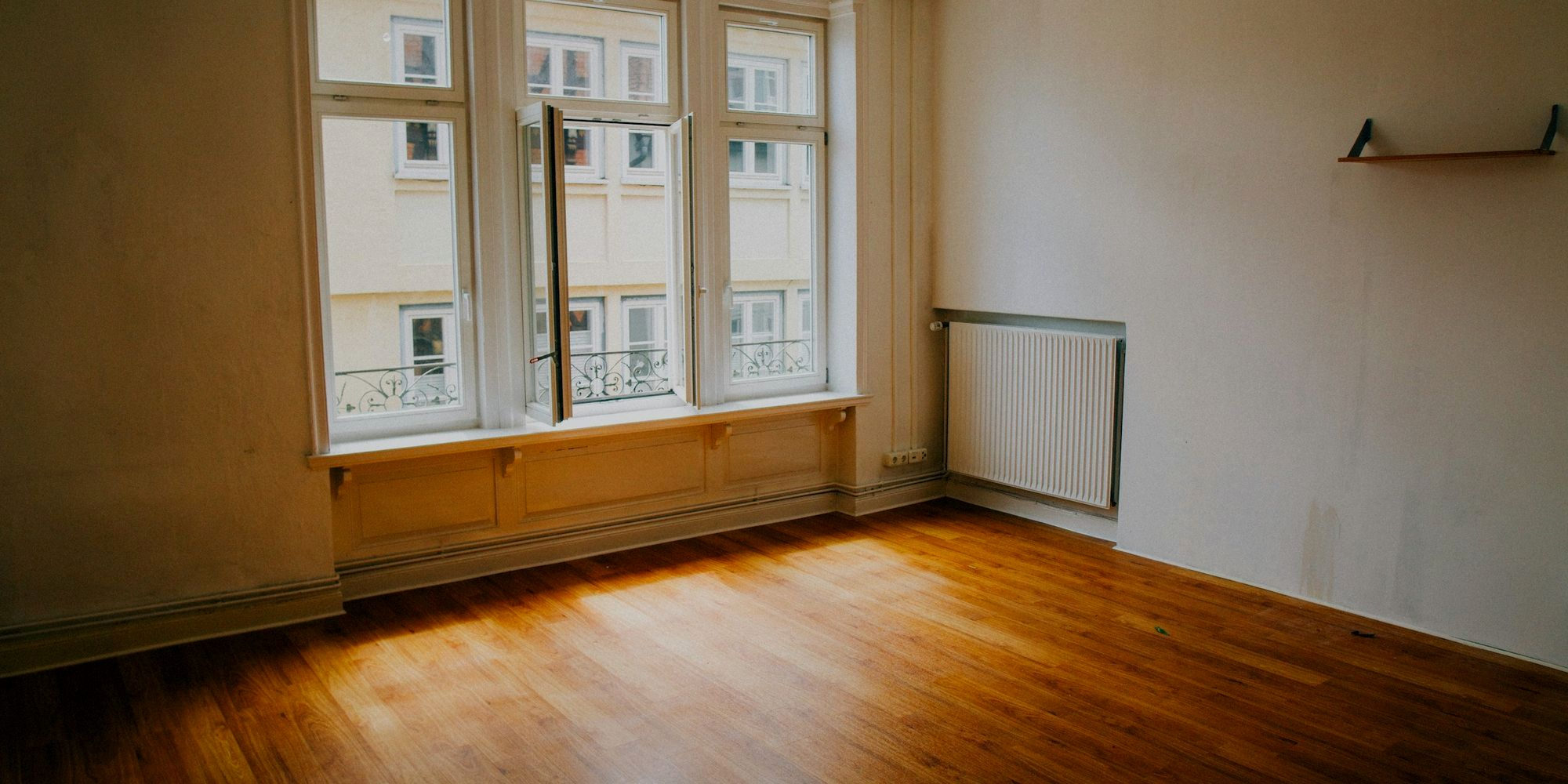 Treatment room one — an empty room with a wooden floor and tall windows, mid-morning.